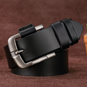 Close-up of black leather belt with silver needle buckle on brown velvet background