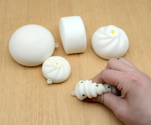 Macro view of hand squeezing soft slow-rebound squishy bun toy for stress relief