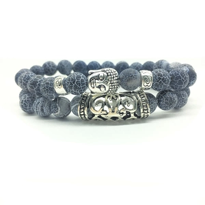 Detailed macro of Buddha head charm and weathered gray dragon vein agate beaded bracelets