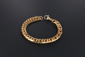 Detailed close-up of a gold-plated cuban link bracelet with a secure lobster clasp