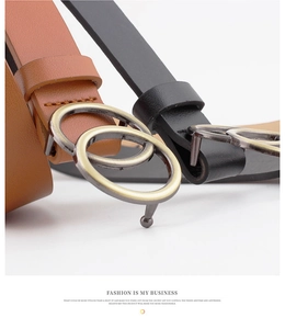 Detail of round double-ring buckles in matte gold on brown and black leather belts