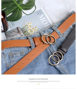 Close-up of double golden ring buckle belts on jeans in brown and black leather