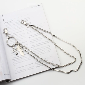 Double-layered silver metal wallet chain with cross and feather pendants on magazine