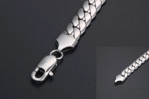 Detailed close-up of a silver stainless steel Cuban link bracelet with a lobster clasp