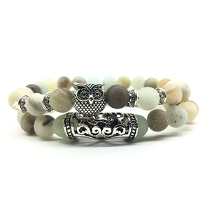 Detailed shot of beaded owl bracelet with matte natural stone beads and silver owl charm