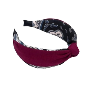Cerchietto annodato in tessuto bordeaux con motivo paisley blu su sfondo bianco