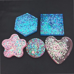Detailed view of DIY resin coasters in star and heart shapes with glitter sequins