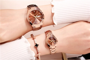 Close-up of rose gold quartz watch with zircon markers and clover bracelet set