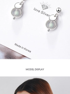 Detailed view of silver strawberry crystal earrings with Korean craft on display card