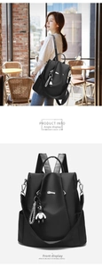 Close-up of black oxford backpack with a white bear pendant and adjustable straps
