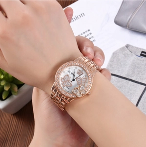 Close-up of rose gold watch with crystal bezel and butterfly dial on a model's wrist