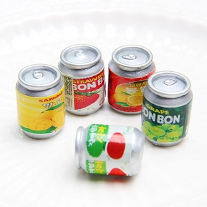 Macro shot of five assorted miniature fruit juice cans on a white plate for DIY jewelry