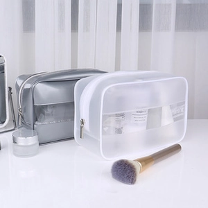 Detail of grey and frosted white PVC toiletry bags with zipper and soft textures