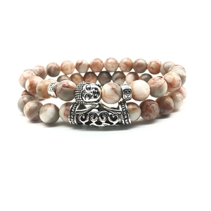 Detail of beaded bracelets with silver Buddha charm and natural weathered agate stones