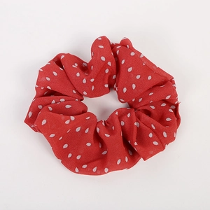 Detail of red chiffon scrunchie with white polka dots and elastic fabric texture