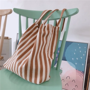 Detail showing the vertical brown and white stripes on a soft canvas tote bag