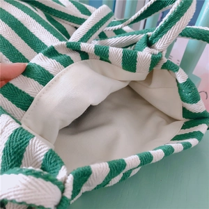 Detailed view of the green striped canvas bag showing interior lining and durable stitching
