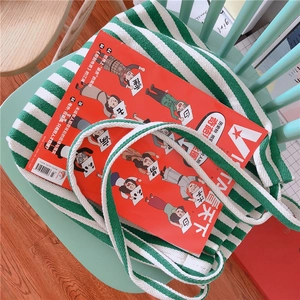 Close-up of green and white striped canvas tote bag with thick woven shoulder straps