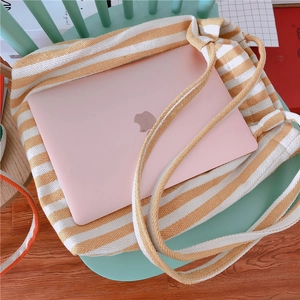 Detail of yellow striped canvas tote bag showing interior space for laptop storage
