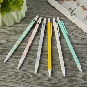 Close-up of seven assorted colorful mechanical pencils on a natural wooden desk background