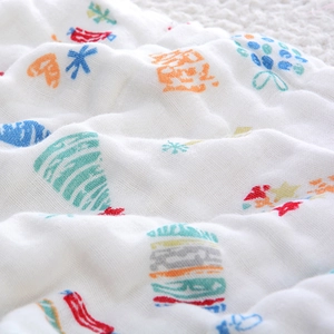 Macro view of 6-layer cotton gauze towel featuring colorful cartoon candy prints