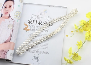 Detail of multi-row pearl elastic belt with rectangular clasp on fashion magazine