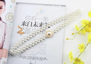 Detail of multi-strand pearl waist chain with vintage gold buckle and white pearls