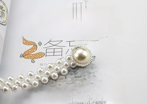 Detail of elegant pearl waist chain with rhinestone buckle and gold metal finish