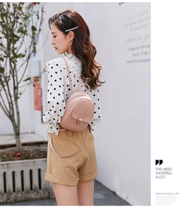 Outdoor shot of a pink PU leather mini backpack with a metal clasp on a model