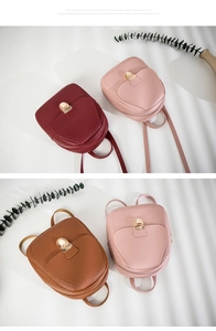 Detail view of mini PU leather backpacks in burgundy, pink and brown with metal locks