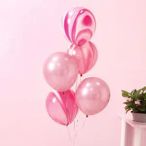 Detailed view of five marble-patterned latex balloons with elegant pink and white swirls