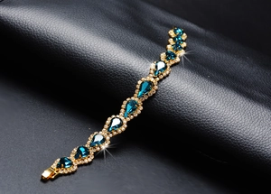 Vue détaillée du bracelet doré avec cristaux en goutte bleus sur cuir texturé