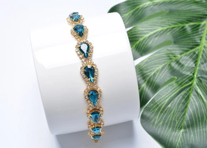 Vue détaillée du bracelet doré avec pierres en goutte bleues et petits cristaux