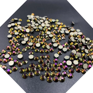 Macro shot of circular golden glass rhinestones for nail art decoration on a dark surface