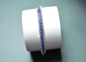 Detailed macro view of the sparkling blue and silver rhinestone tennis bracelet on stand