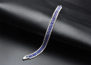 Detail view of multi-row silver bracelet with blue and clear rhinestones on black leather