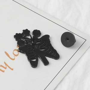 Skull butterfly enamel pin with floral ribcage design and black rubber clutch backing