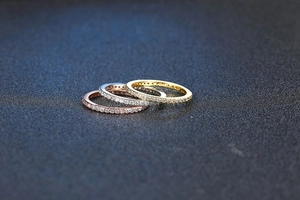 Close-up of three eternity rings in rose gold, silver, and gold with micro-pave zircons
