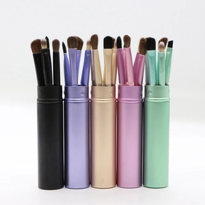 Detailed view of five portable eye makeup brush sets with matching cylindrical storage cases