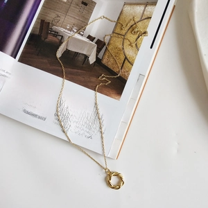 Detailed close-up of S925 sterling silver stamp on a gold-plated wreath necklace