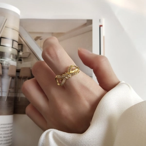 Detailed view of a gold-tone 925 silver bow ring set with sparkling zircon stones