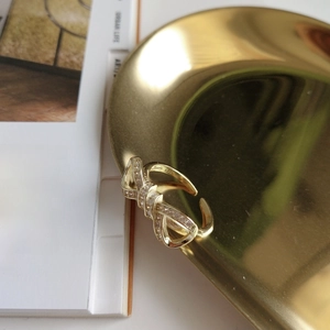 Detail of 925 sterling silver bow ring with gold plating and sparkling zircons
