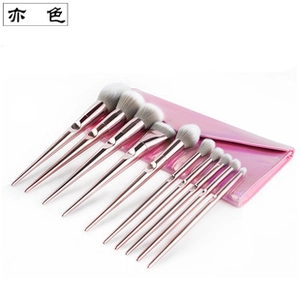 Detail of 10-piece rose gold makeup brush set with a glossy pink iridescent storage pouch