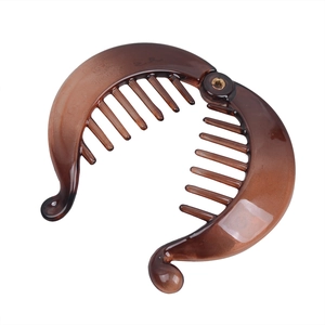 Detailed view of amber brown banana hair clip with double-row teeth and metal hinge