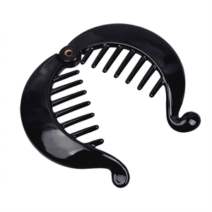 Close-up of black banana hair clip with rounded inner teeth and metal rivet detail