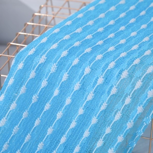 Macro shot of blue nylon bath towel fabric with white wavy patterns and mesh texture