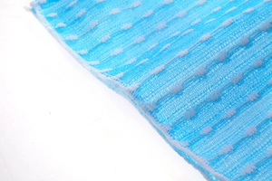 Macro detail of blue nylon mesh exfoliating back scrubber with woven texture