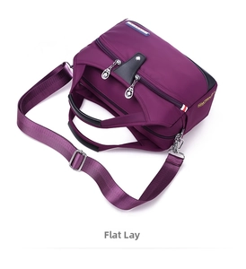 Detail of purple waterproof nylon bag with multiple zipper pockets and adjustable strap