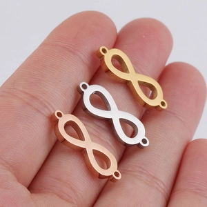 Infinity symbol jewelry connectors in gold, silver and rose gold on a palm hand
