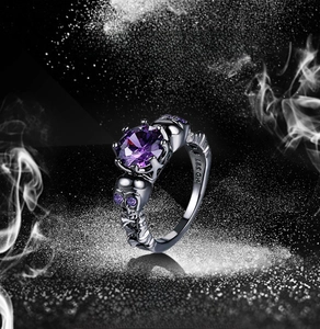Macro shot of skull ring features a purple cubic zirconia stone and 18K GP hallmark
